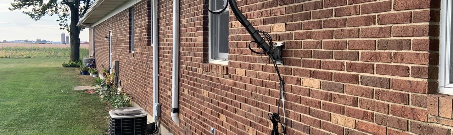 The long side wall of the Ohio ranch house in 2019, red brown brick running one range down its length under a white soffit