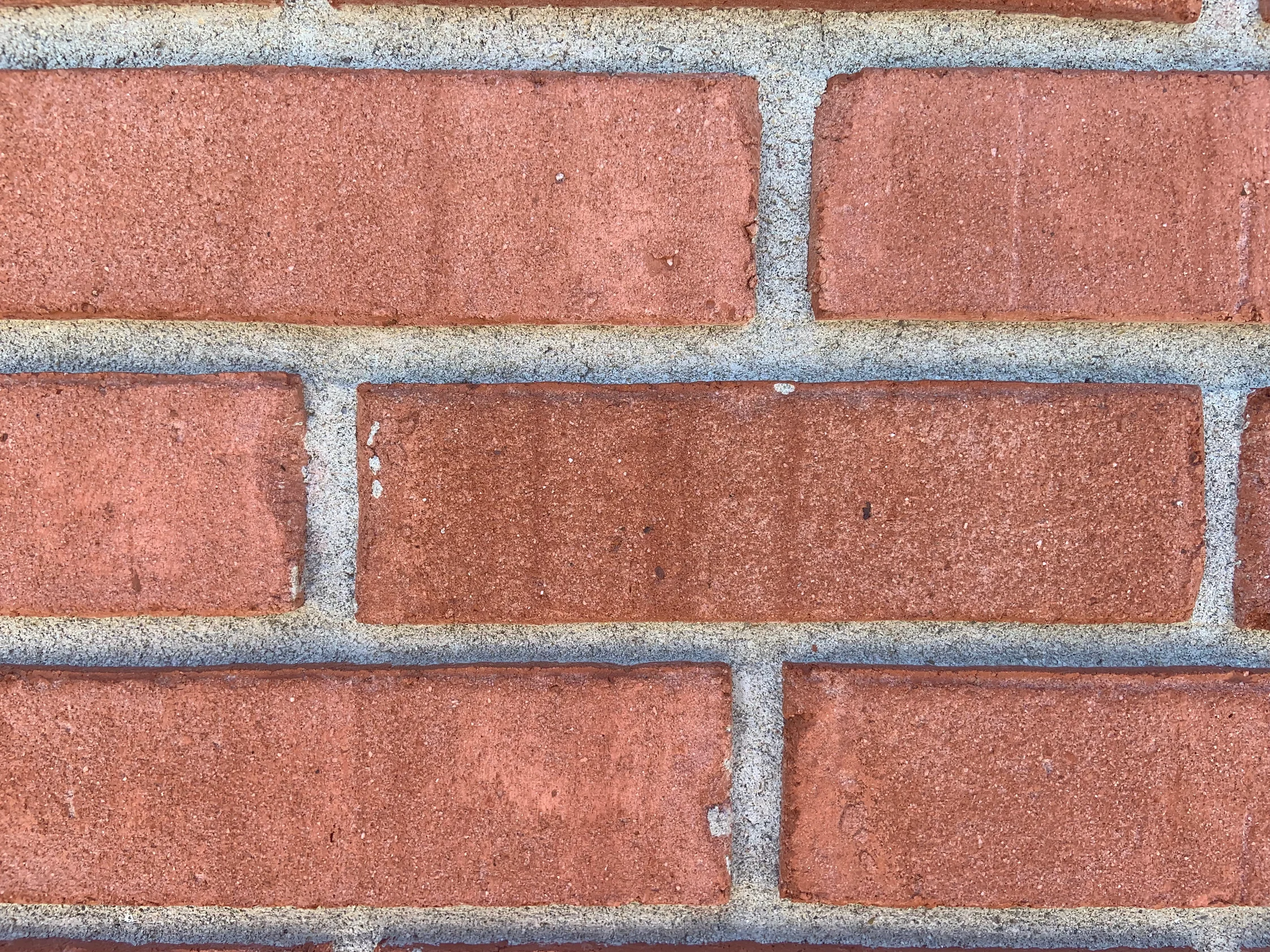 Close view of three courses of the brick in 2019, the color even from face to face with pale mortar joints between