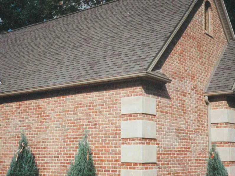 The gable end in 1997, the brick field reading patchy and washed in places beside banded limestone quoins at the corner and around the arched window