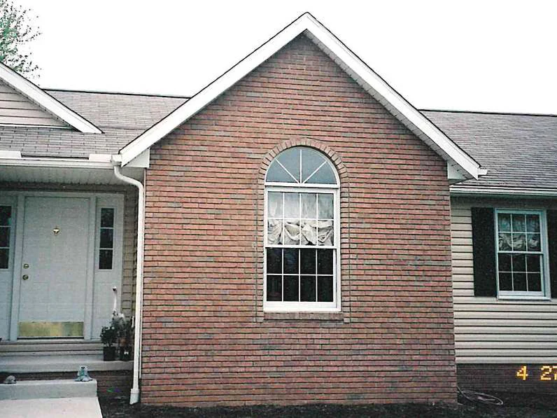 The same gable later in 2002, the brick in the peak and the arched header reading as one range beside the front entry door