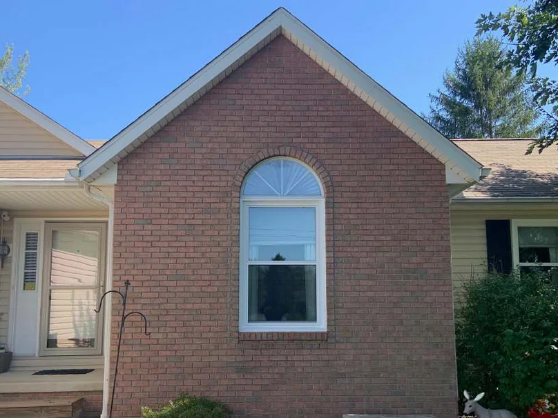The gable in 2019 from about where the 2002 frames were taken, the brick even through the peak and around the arched window, the sided wings either side unchanged