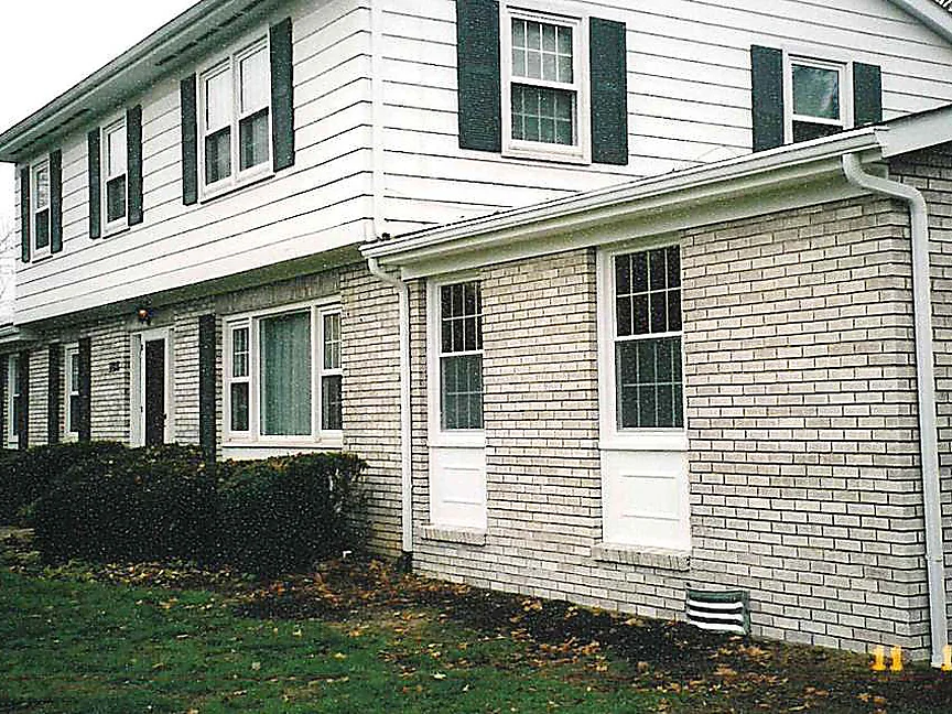 The addition from the side in 2003 with the work finished, its brick reading as the same cream range as the original wall running away behind it