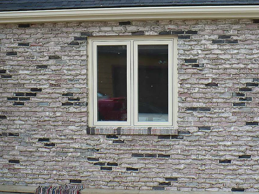 The same wall in 2008 with the work finished, the brick reading as a grey and lavender range with dark units scattered through the courses