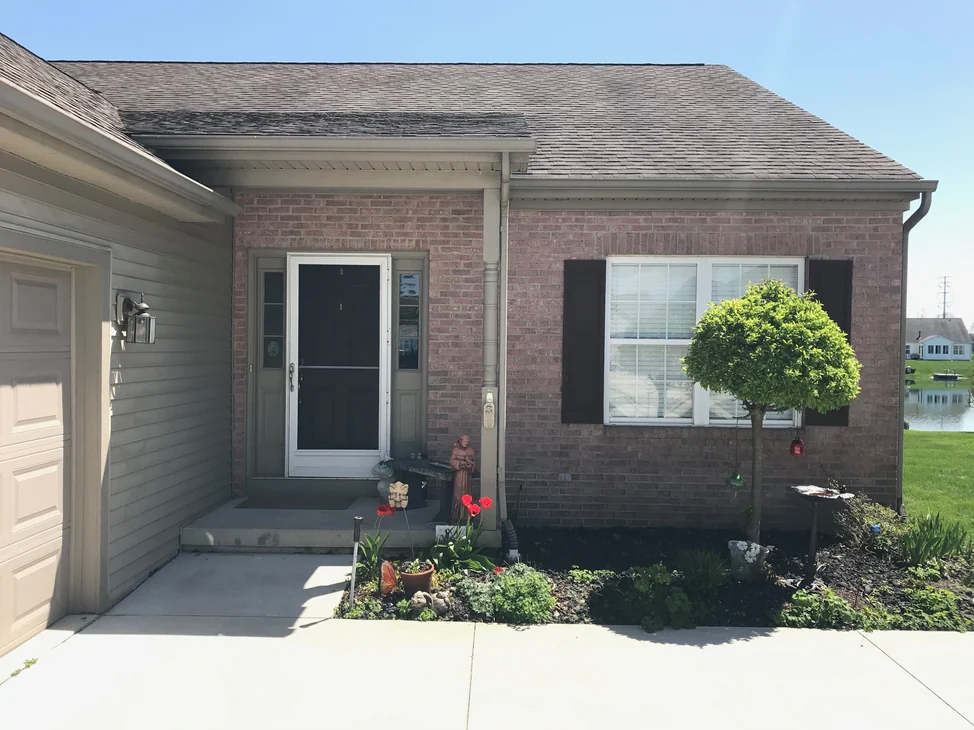 The front entry of a single-story brick home in 2019, the brick reading as one even color across the wall