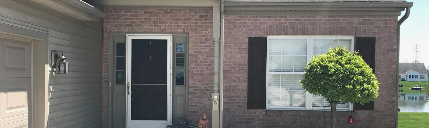 The front entry of a single-story brick home in 2019, the brick reading as one even color across the wall