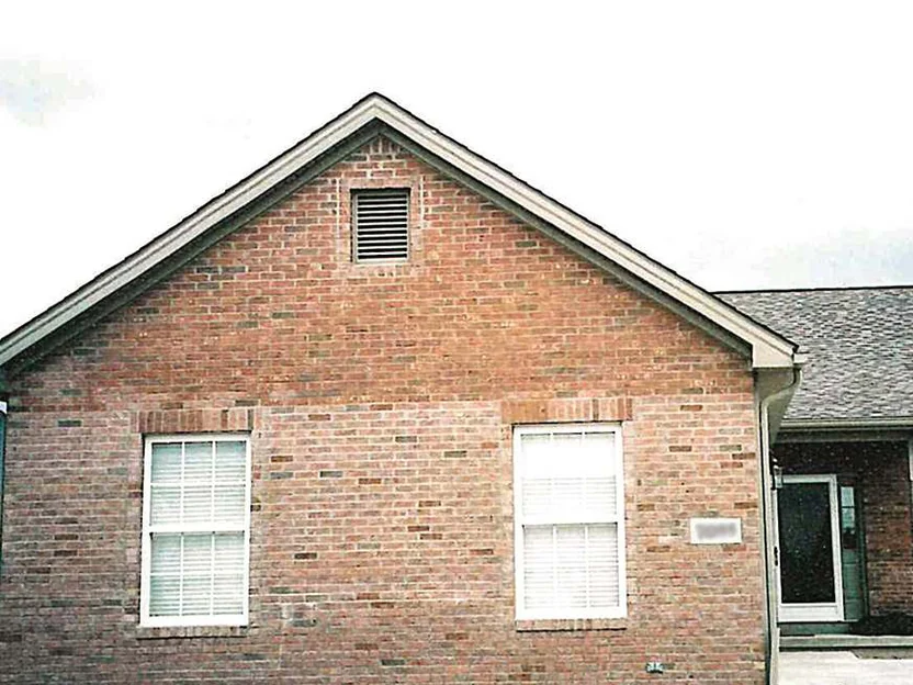 The gable end of the house in 2002, its brick blotched with pale and dark units from the ground to the ridge