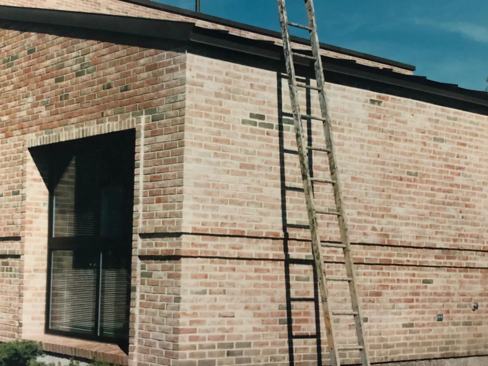 A ladder standing against the library corner during the 1986 work, one face reading warm red and the return face pale cream
