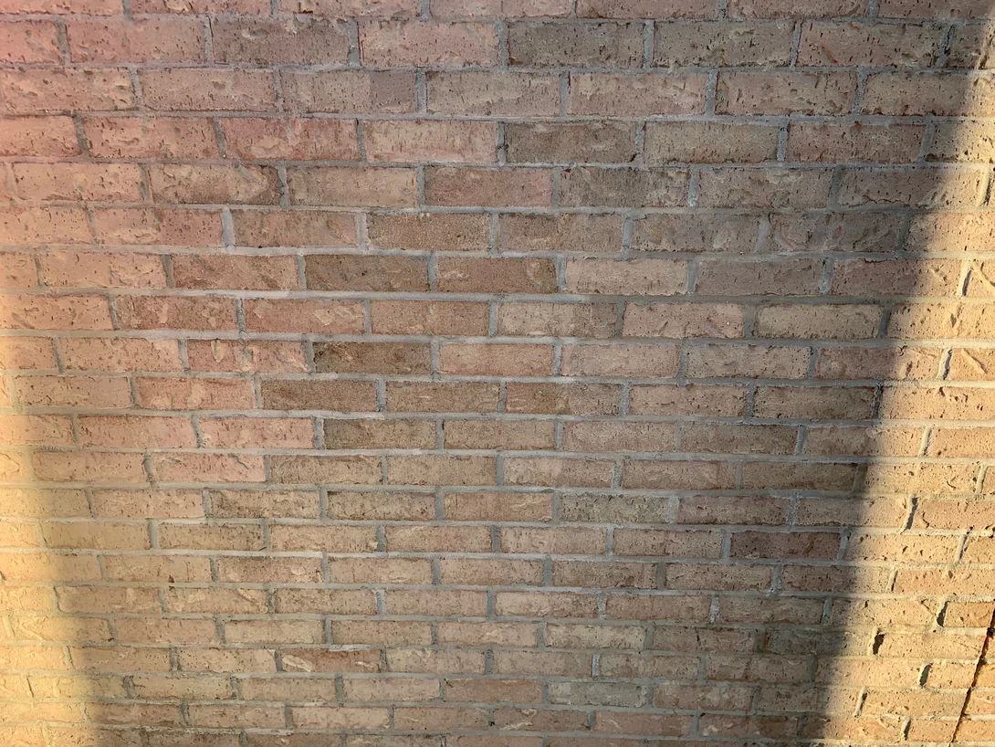 Close view of the brick in 2019, the units reading as one range of tan and soft pink with grey mortar joints