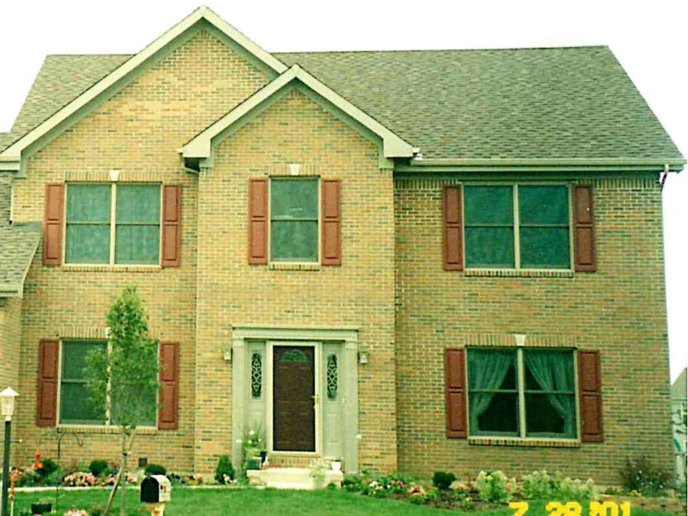 The front of the house in 2001 before the work, pale patches of brick standing out of the range across the large gable and the wall above the entry