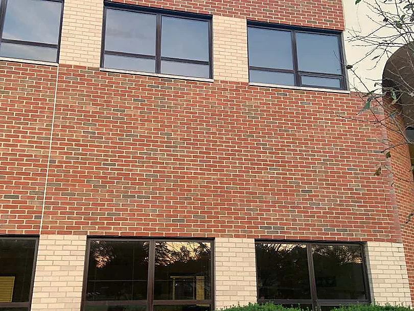 The same two floors of the elevation in 2019, the vertical colour break gone and one red range carrying across both window bands