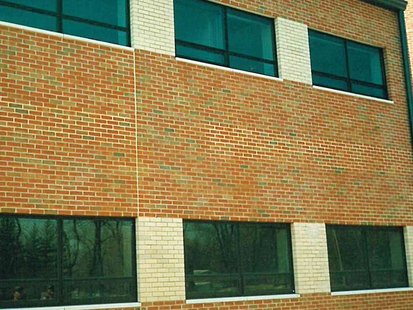 Two floors of the elevation in 1998, the brick shifting from orange tan on the left to a pinker red on the right down a vertical line between the window bays