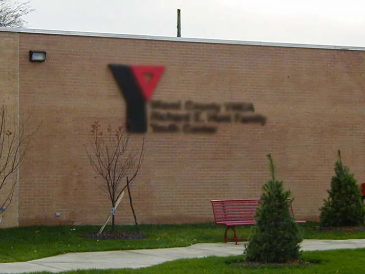 The same elevation from an angle later in 2002, the fill-in panel no longer separating from the buff brick, with newly planted trees and a red bench along the walk
