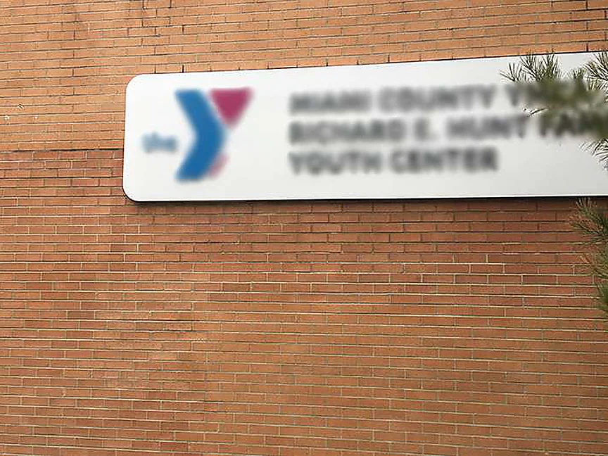 The wall close up in 2019, courses running evenly across the full width below and around the building sign with no patch reading through