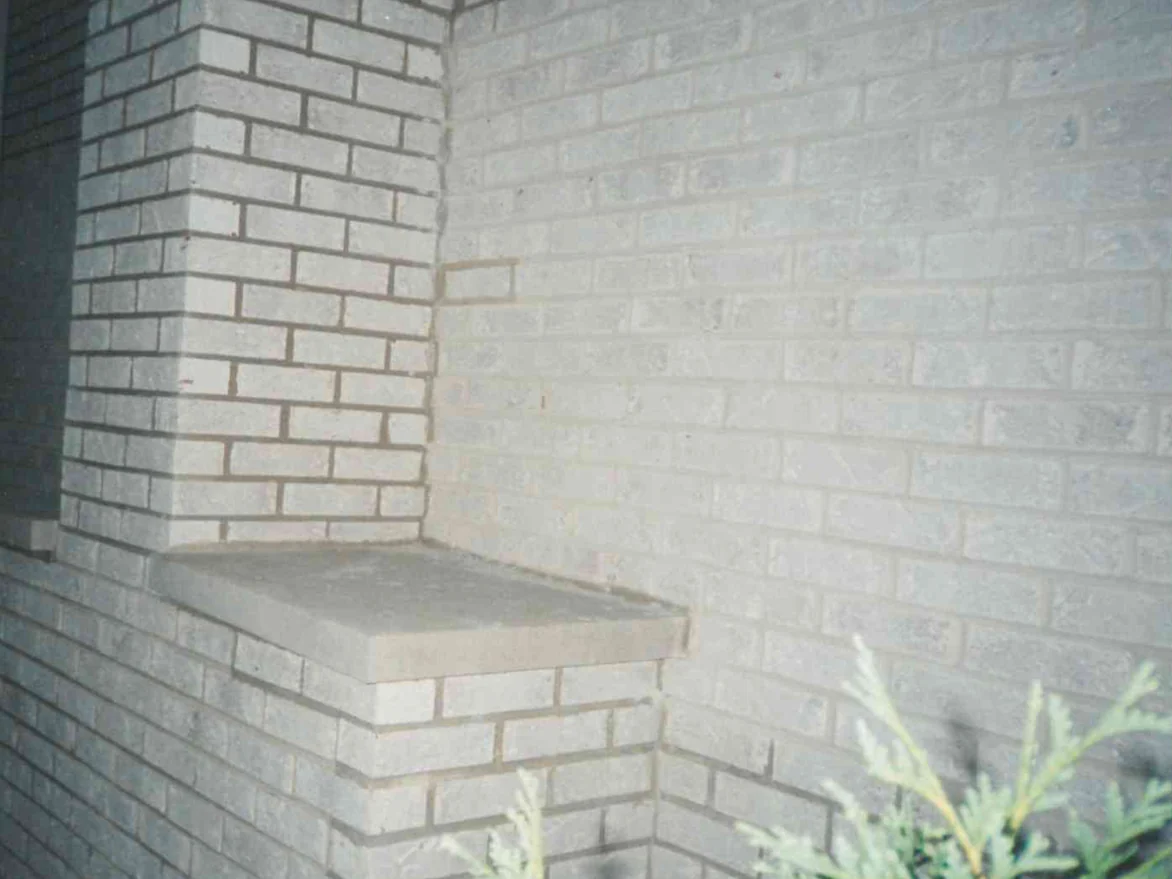 A projecting brick pier with a flat stone sill against a wall of the same pale brick in 1998, the joints reading darker than the brick throughout