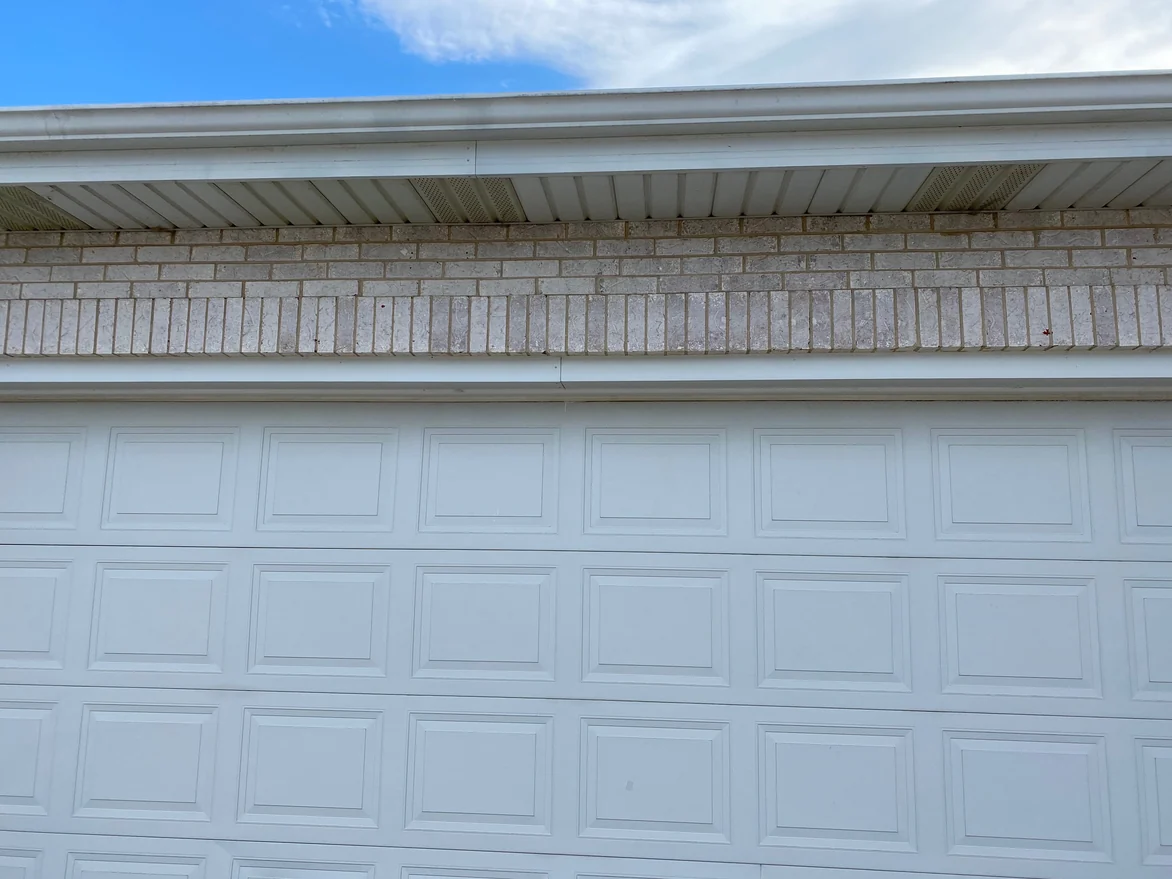 A close view in 2021 of the soldier course and the brick above it over a garage door, the joints reading as one light color the length of the run