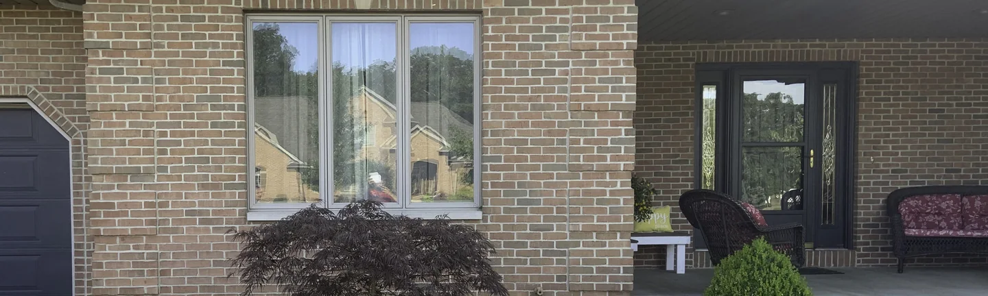 The front of the Osgood house in 2019, its brick reading as one even range beside the covered porch
