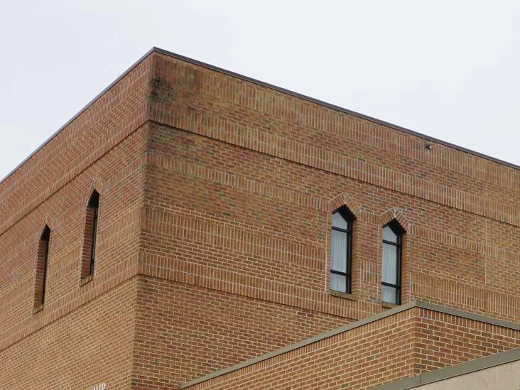 The upper corner of the church in 2019, the second story brick one range with the courses below it, pointed arch windows on both elevations
