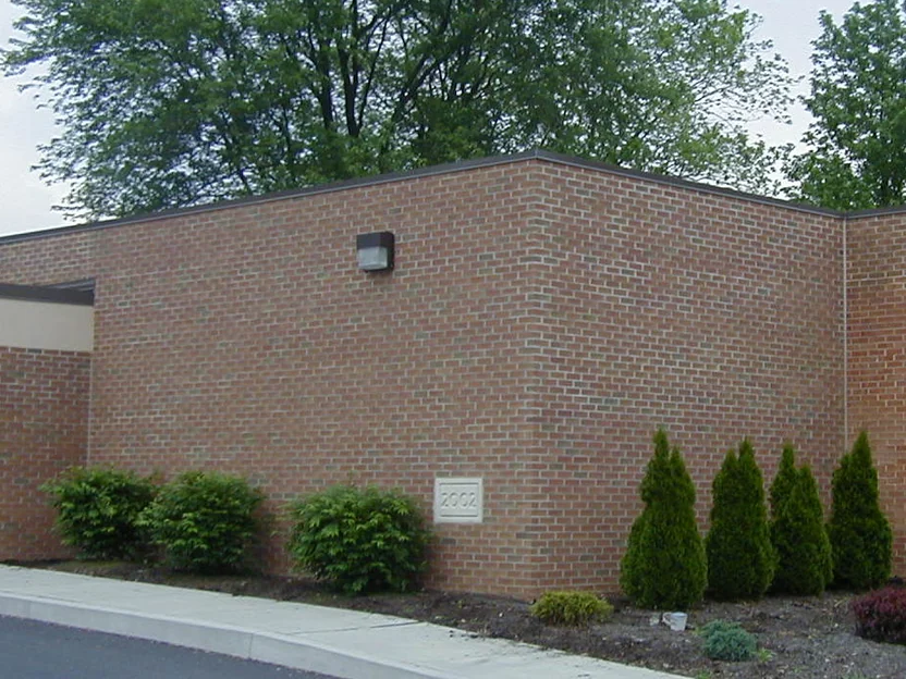 The same entrance wing later in 2004, the brick reading one even range from the canopy to the far corner, the stone plaque still in the wall