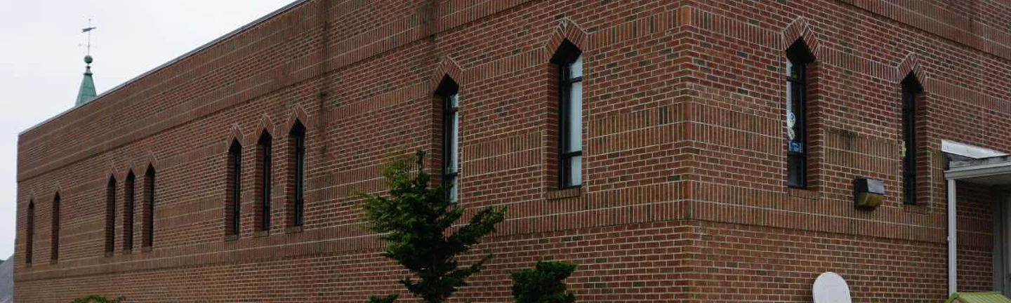 The long side of the church in 2019, the second story brick one range with the original walls below it