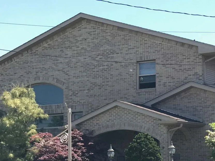 The same front gable nineteen years on, the brick reading as one range from the ridge down to the porch roof