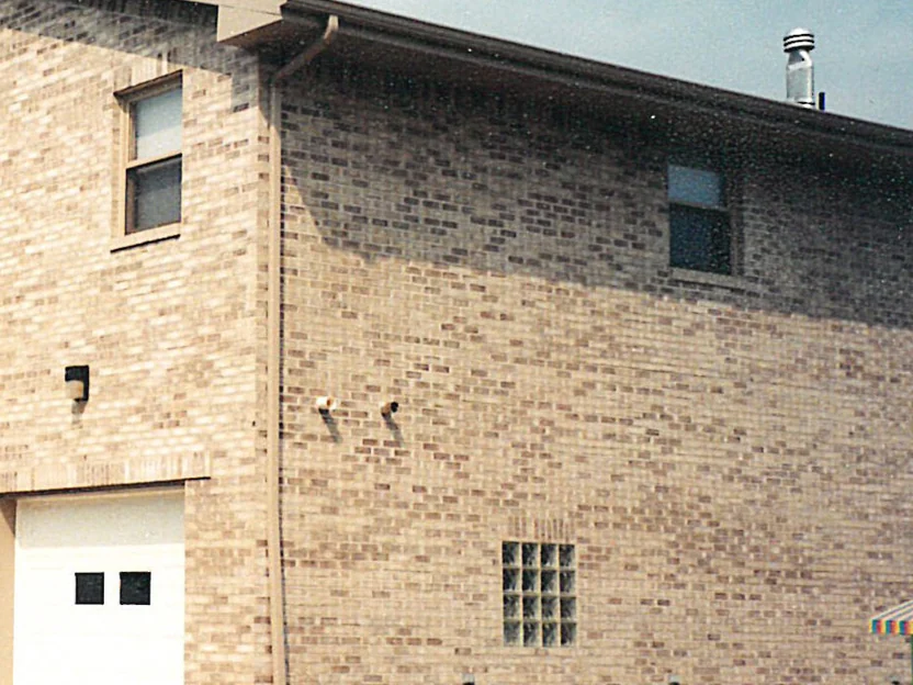 The side wall of the funeral home in 2000, the upper courses reading much darker than the paler brick below them