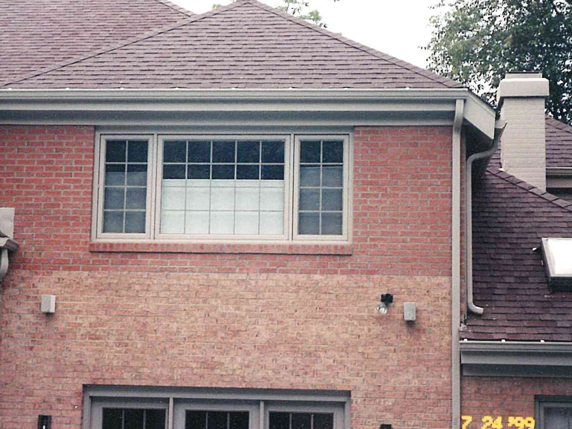 The back wall of the house in 1999, the courses above the window band reading a deeper red than the lighter, patchier brick running across the wall below it