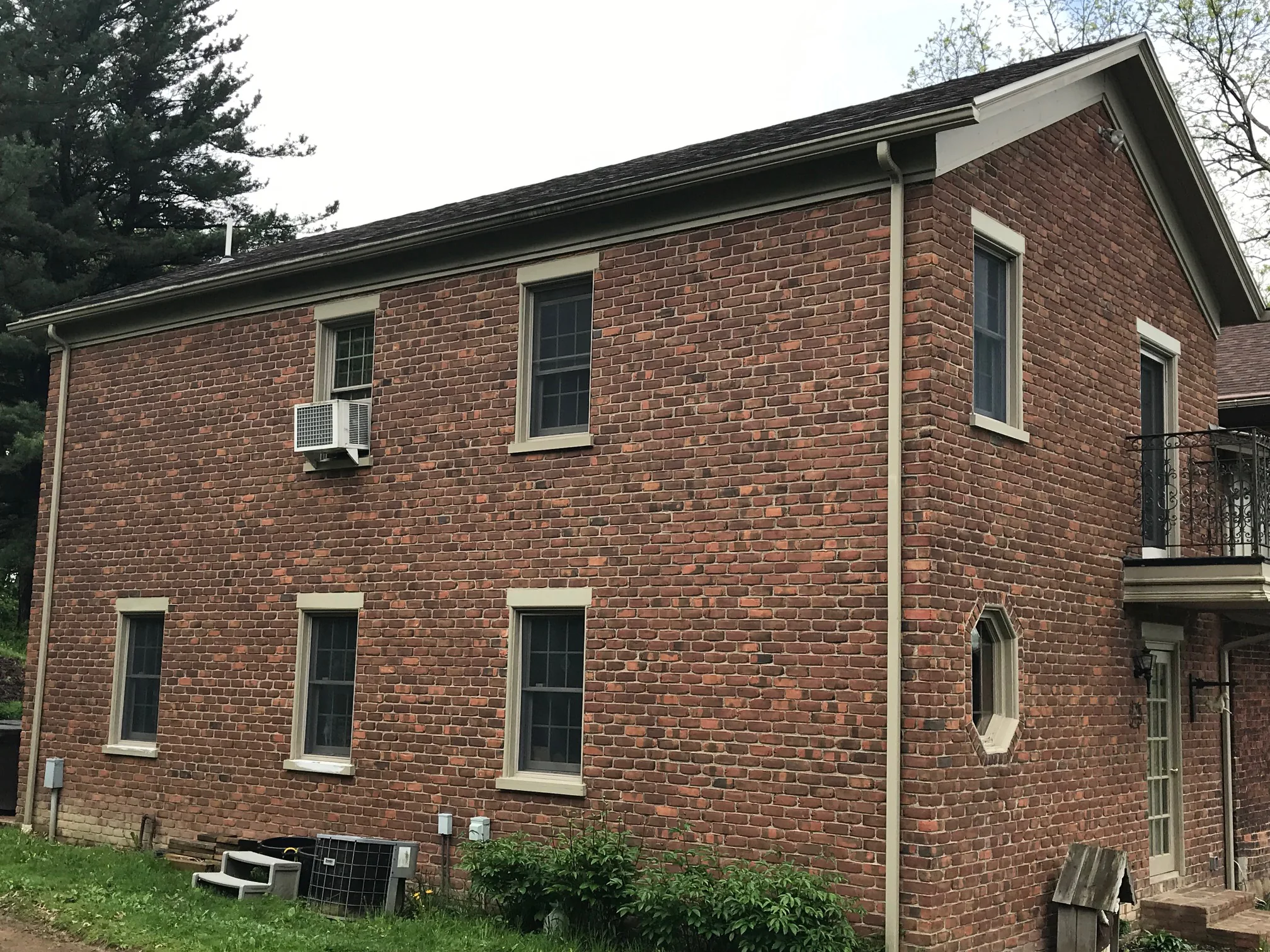 The long side wall of the house in 2019, three windows on each floor and the brick carrying the same range from the far end to the corner