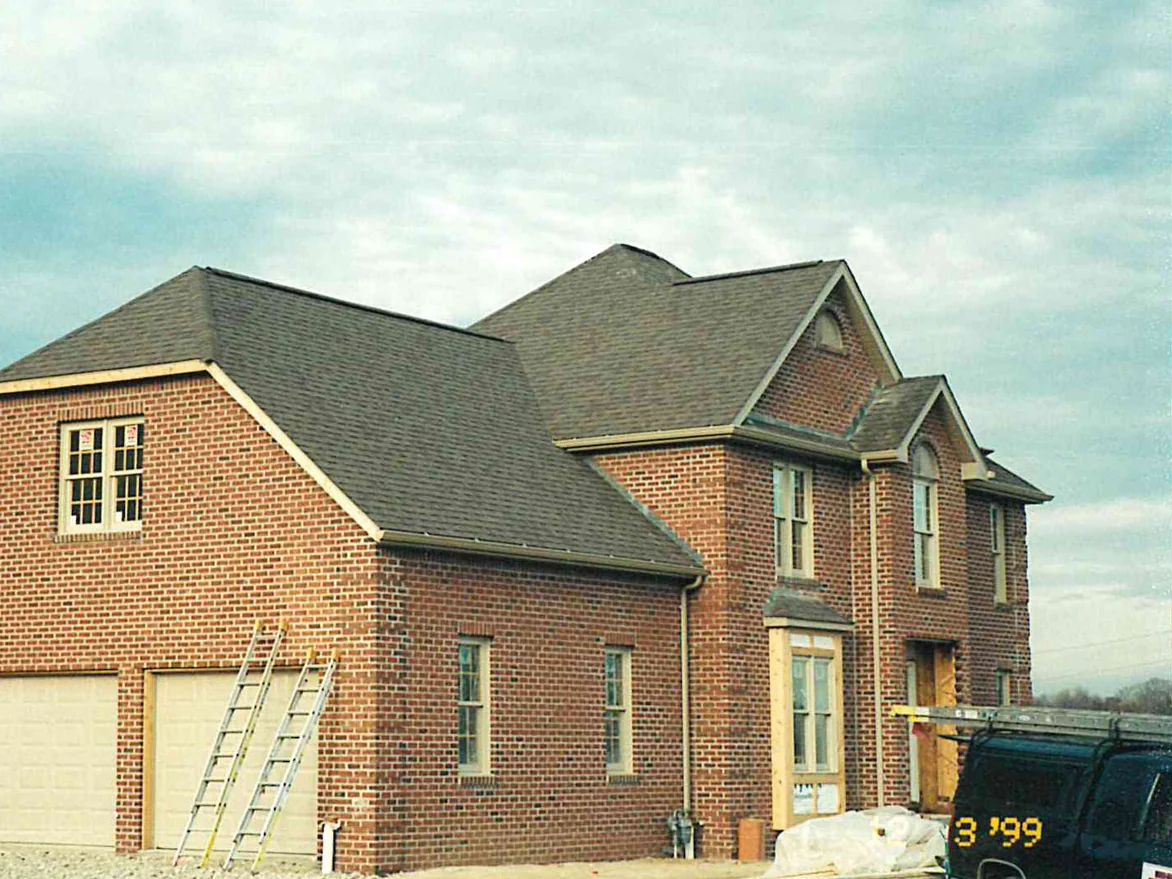 The house under construction in 1999, seen from the corner with ladders at the garage end and a van in the drive