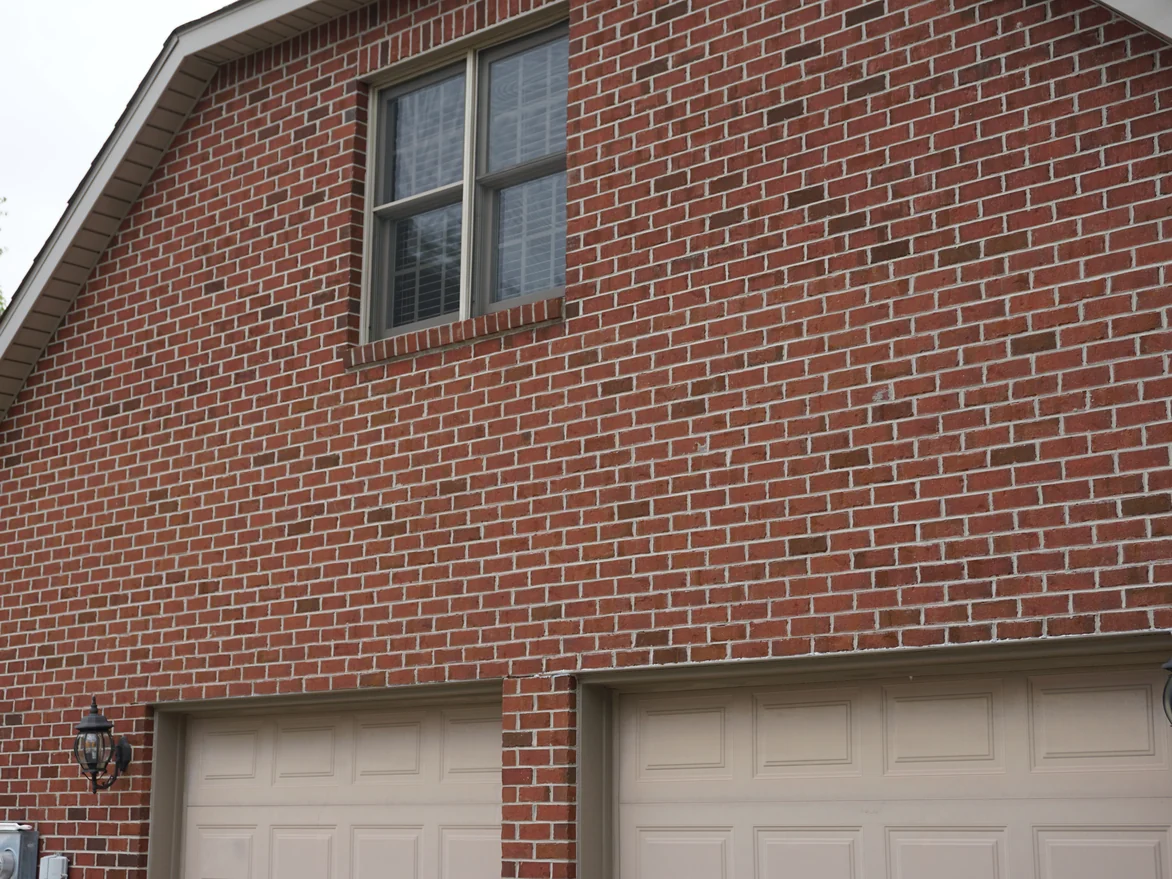 The garage gable seen at an angle in 2019, the brick above the door heads even in tone across the whole wall