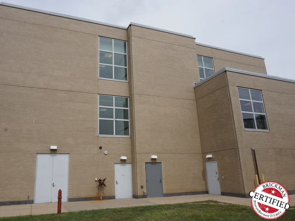 Two storeys of buff brick on the hospital's rear elevation in 2019, with service doors along the ground floor.