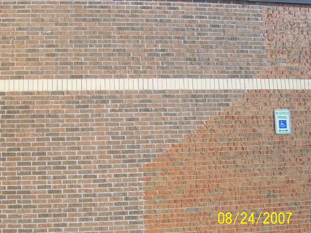 The wall beside the entrance in 2007, a field of pale salmon and grey brick meeting a redder, rougher brick down a vertical line, with a cream banding course across both