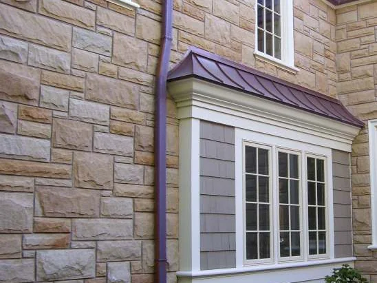 The addition wall in 2006, pale cream stone running past a copper roofed bay window and a downspout