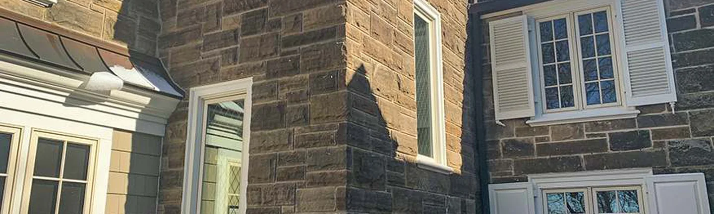 The addition's stone corner in 2021, running to the original stone wall on the right with snow on the slate roof above