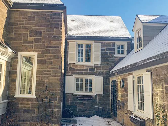 The courtyard side in 2021, stone on the addition and on the older wing reading as one range across an inside corner, snow on the ground