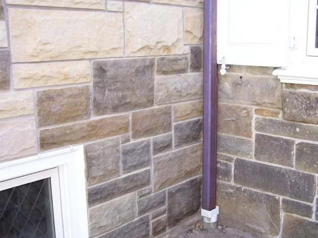 The same inside corner during the work in 2006, single stones carried into range one at a time against the untreated pale stone above them