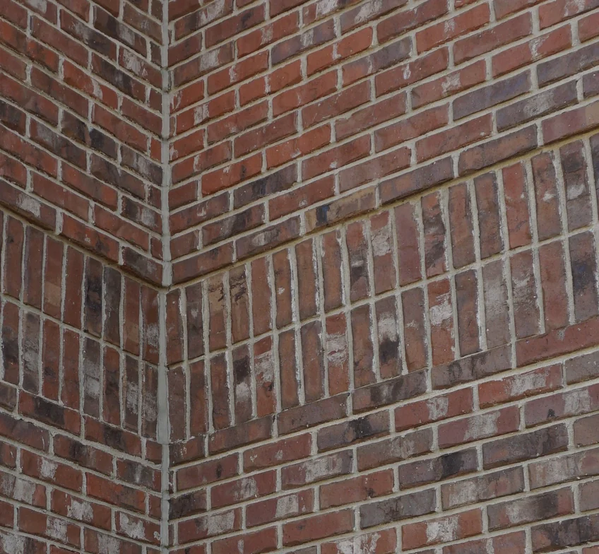 Close view of the blended brick at the same outside corner in 2019, an accent course of upright units running across both faces