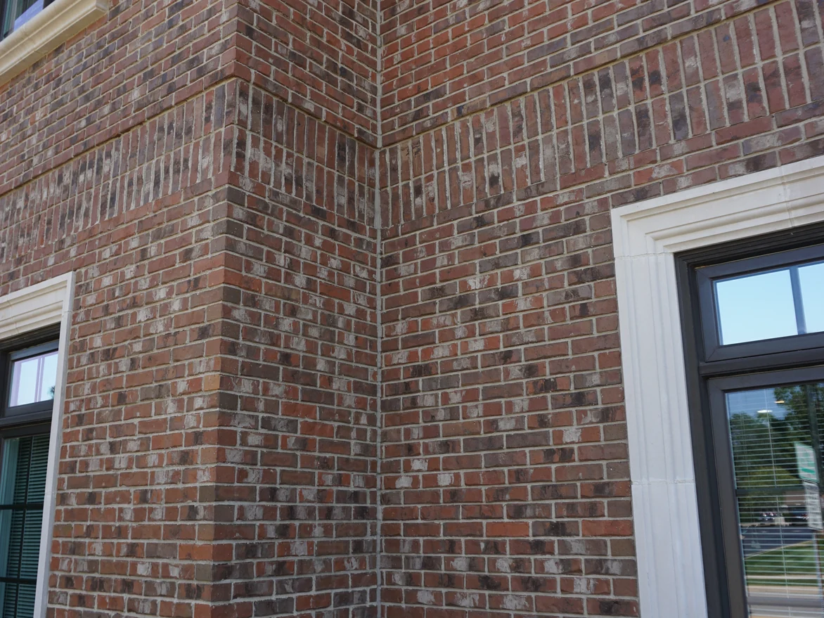 An outside corner of the office running from the ground to the eaves, the brick evenly blended on both faces