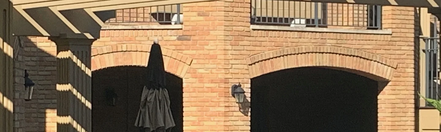 The brick arcade at the back of the Powell house in 2019, arch heads and column corners in the same range as the brick around them