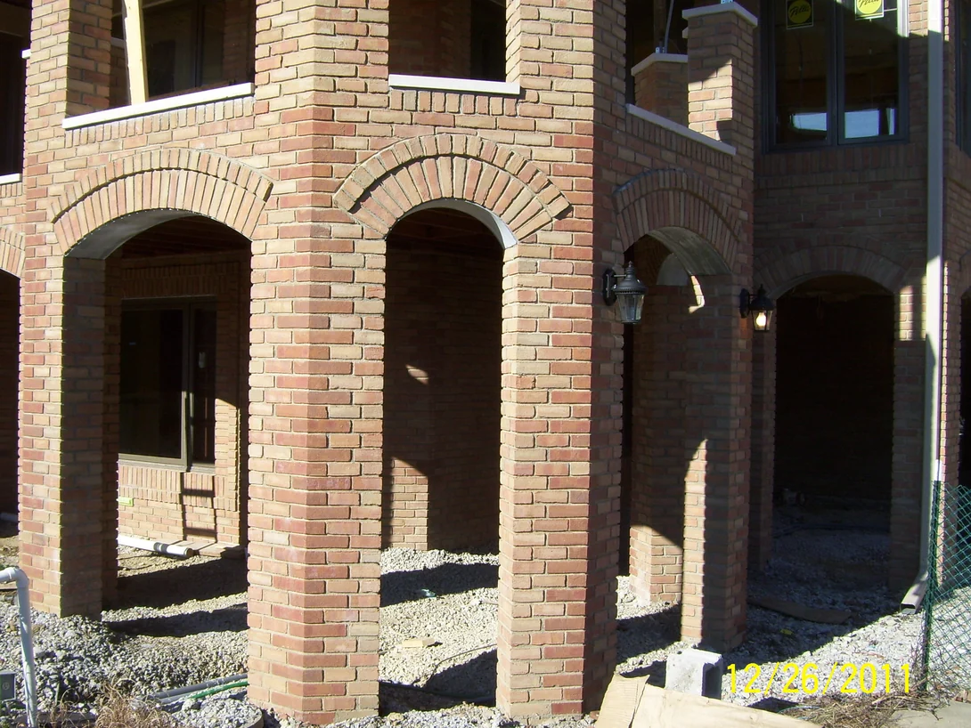 The brick piers and arches close up, the tapered shapes over each opening a lighter, pinker color than the brick they sit in