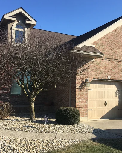 A house in 2021, its garage and gable one even brick range twenty-four years after the damaged areas were stained