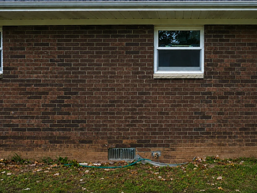 Brick wall after staining, with the replacement-brick patch blended in to match the original masonry