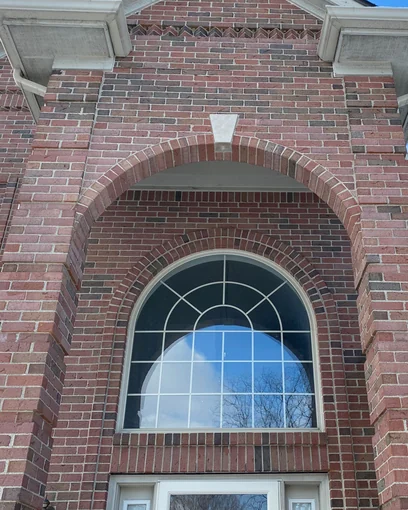 The arched entry of a Rochester Hills, Michigan home in 2021, both shipments of brick reading as one range