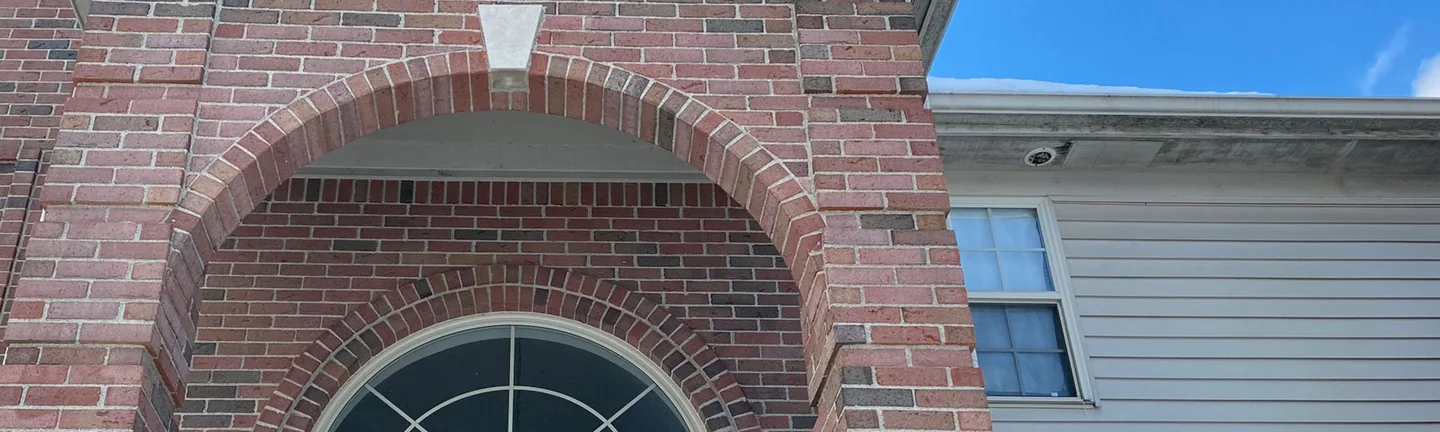 The brick entry arch of the Rochester Hills house in 2021, one range of red brick from the pier to the wall beside it
