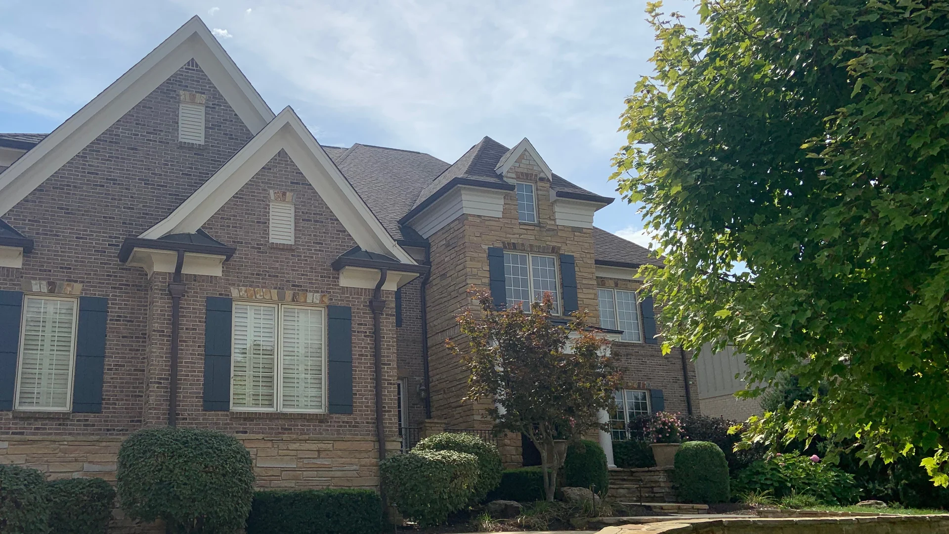 A two-story brick and stone house in Indiana in 2019, its brick and mortar one even range twelve years after staining