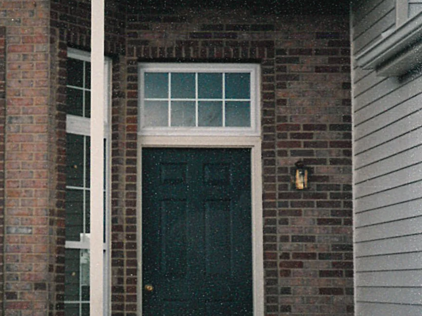 The front entry in 1997, the brick around the door and across the header course reading much darker than the units beside it