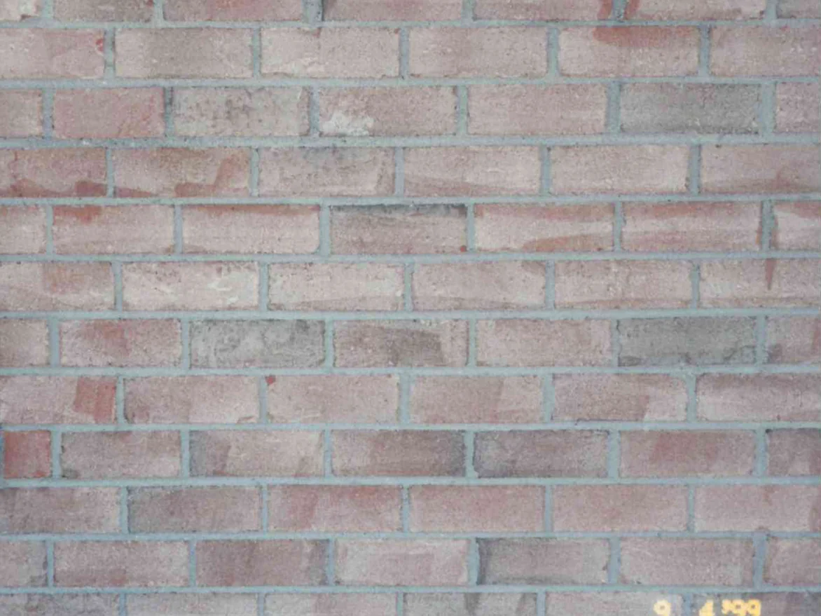 A close-up of the brick in September 1999, the faces streaked and blotched pale and dark with grey mortar joints between them