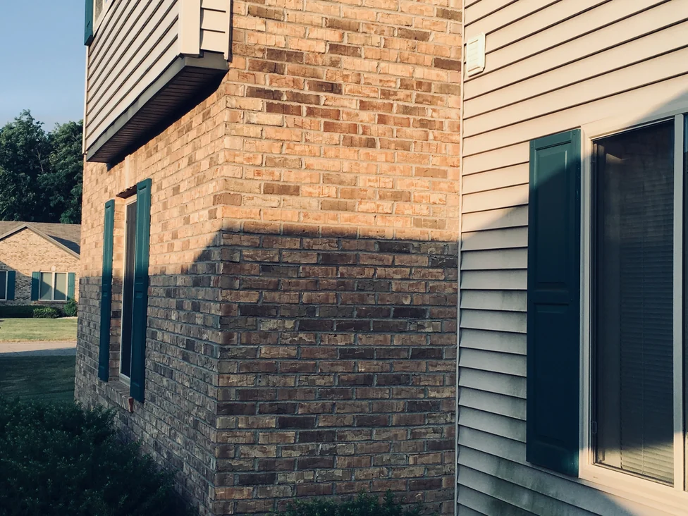 An outside brick corner at Royal Vista in 2019, the blend carrying across both faces through a hard sunline halfway down the wall