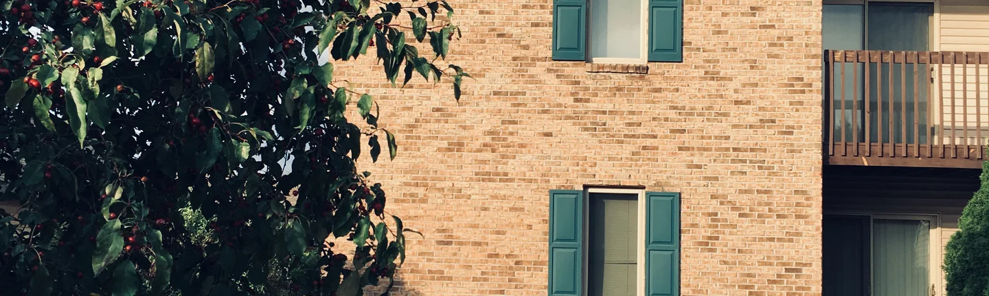 The brick end wall of a Royal Vista apartment building in 2019, one even buff and tan range across the whole elevation