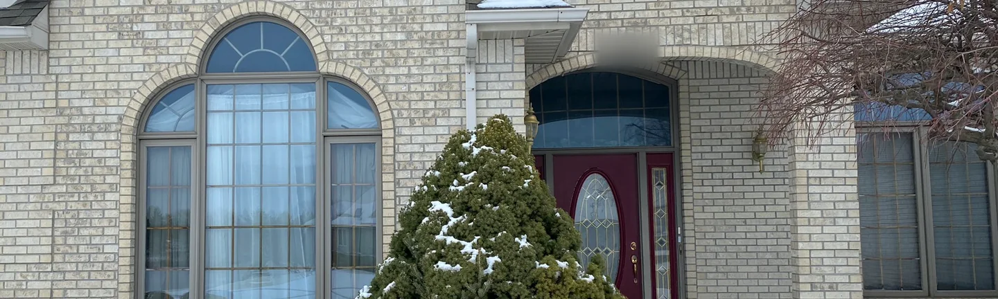 The front of the Saginaw house in 2020, its brick one pale grey and cream range from the gable to the entry arch