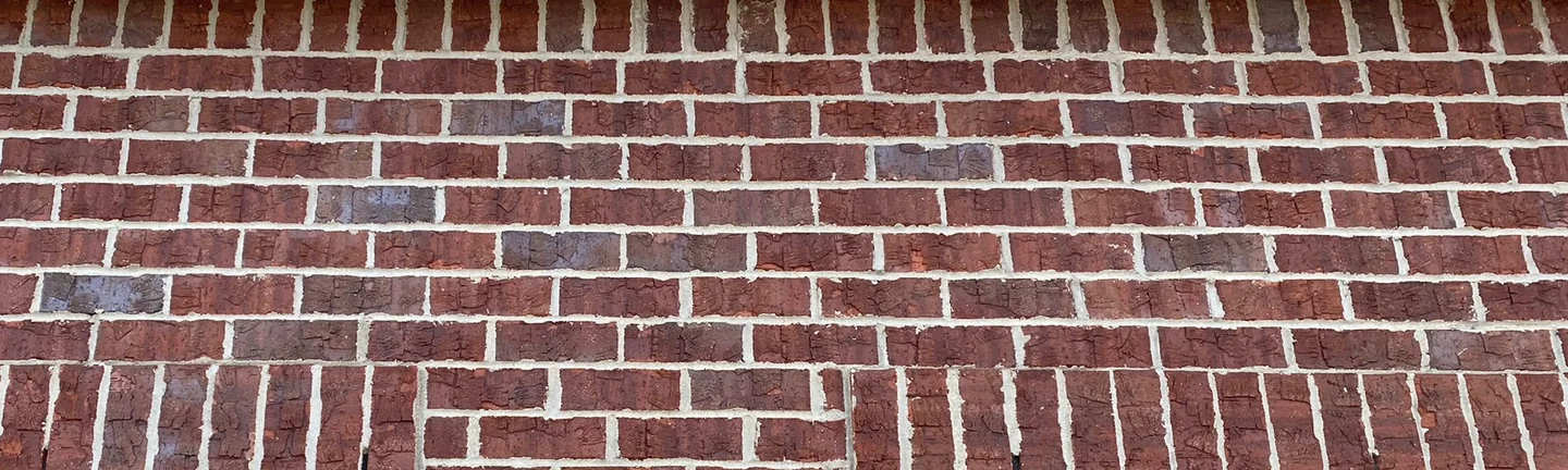 The brick over the garage doors of the house at Saline Estates in 2020, one red range across every course under the soffit